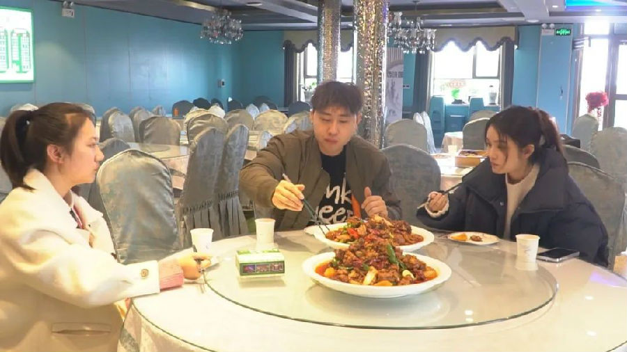 图为市民品尝大盘鸡 （焦祖卿 摄）