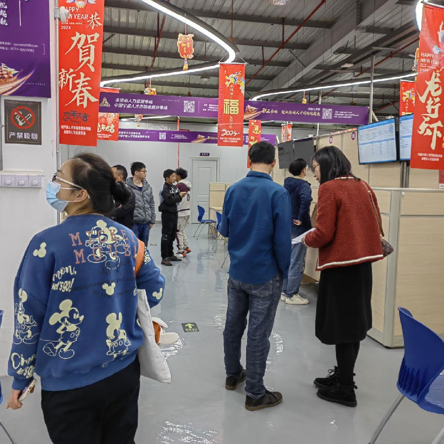 求职者穿梭在各企业的展位前阅读招聘岗位信息 （胡张远 摄）