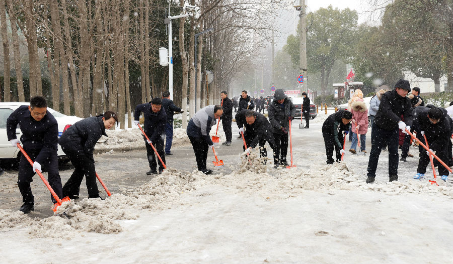 图为“四大家”领导带头在街头铲雪除冰（李勤 摄）