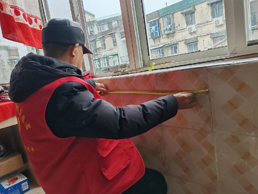 图为刘新平变身泥瓦匠为社区居民修缮阳台（魏涵玉 摄）