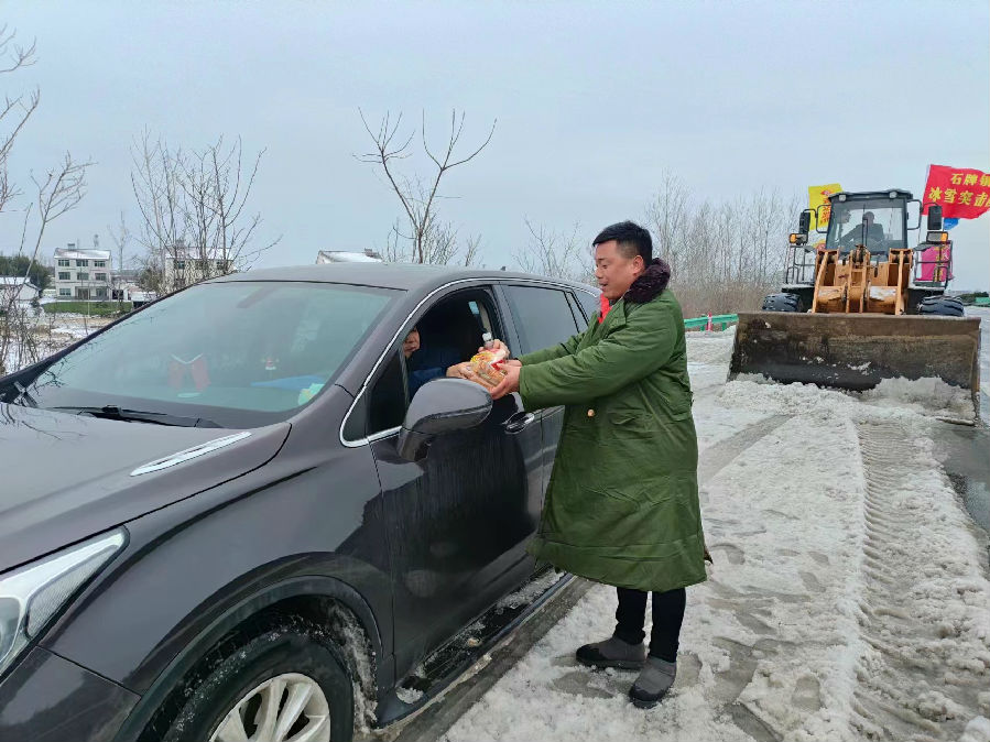图为应急队员贡献自己的口粮给滞留司机（陈美玲 摄）