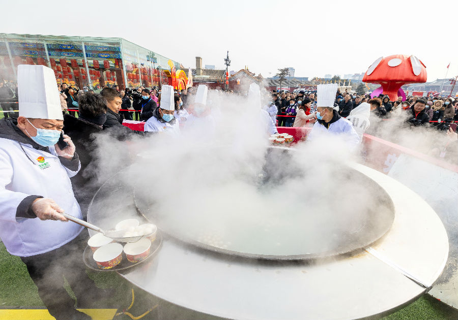 工作人员在呼和浩特市玉泉区塞上老街旅游休闲街区为游人盛元宵 （丁根厚 摄）