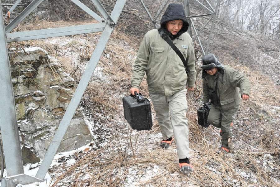 图为国网十堰供电公司的观冰人员上山测量 （朱江 摄）