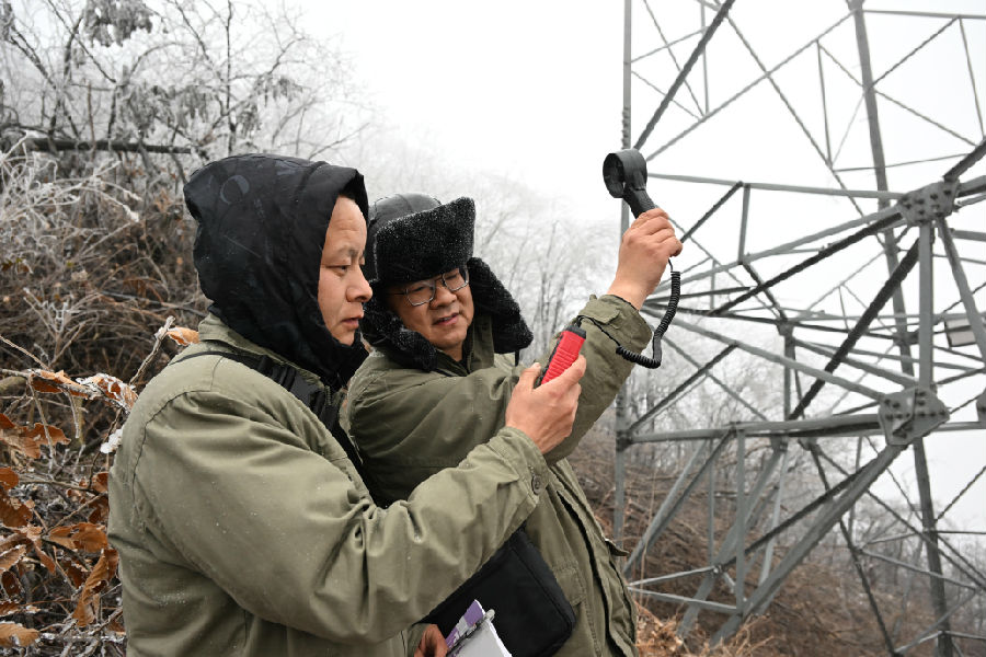 图为国网十堰供电公司观冰员现场测算数据 （朱江 摄）