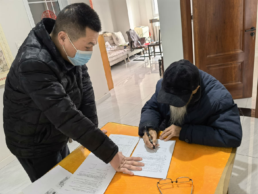 工作人员上门为老人办理不动产转移登记手续 （王慧 摄）