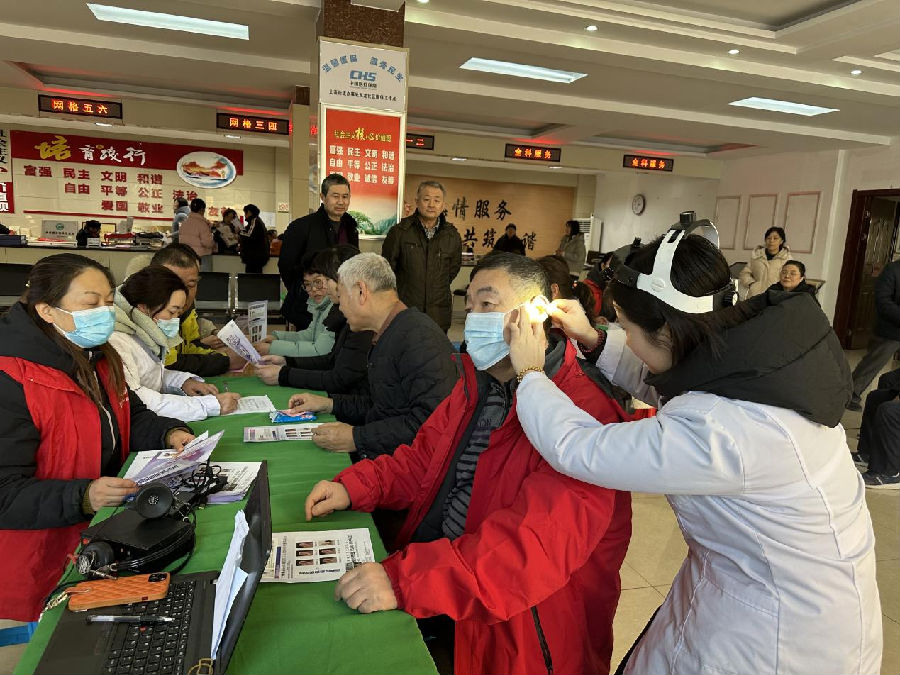 现场医护人员给居民检测耳朵（宋晓旭 摄）