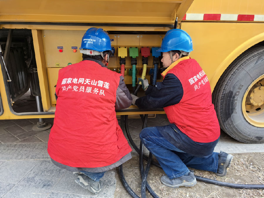 图为国网阿克苏市供电公司党员服务队准备应急电源车接入工作 （马燕 摄)