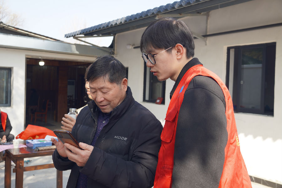 志愿者们帮助老年人学习智能手机的使用 （李晓清 摄）