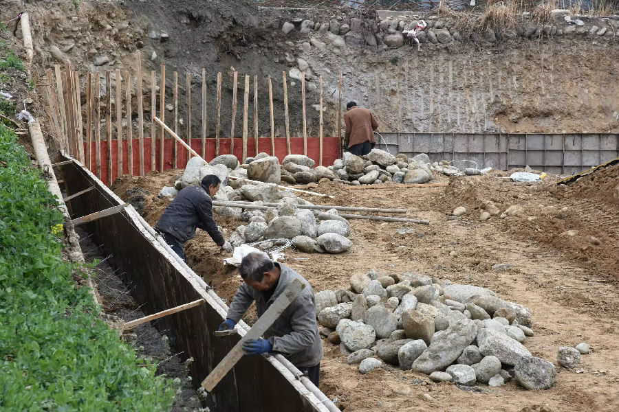 施工人员正在进行挡墙修建、混凝土浇筑等作业 （曹琳 摄）