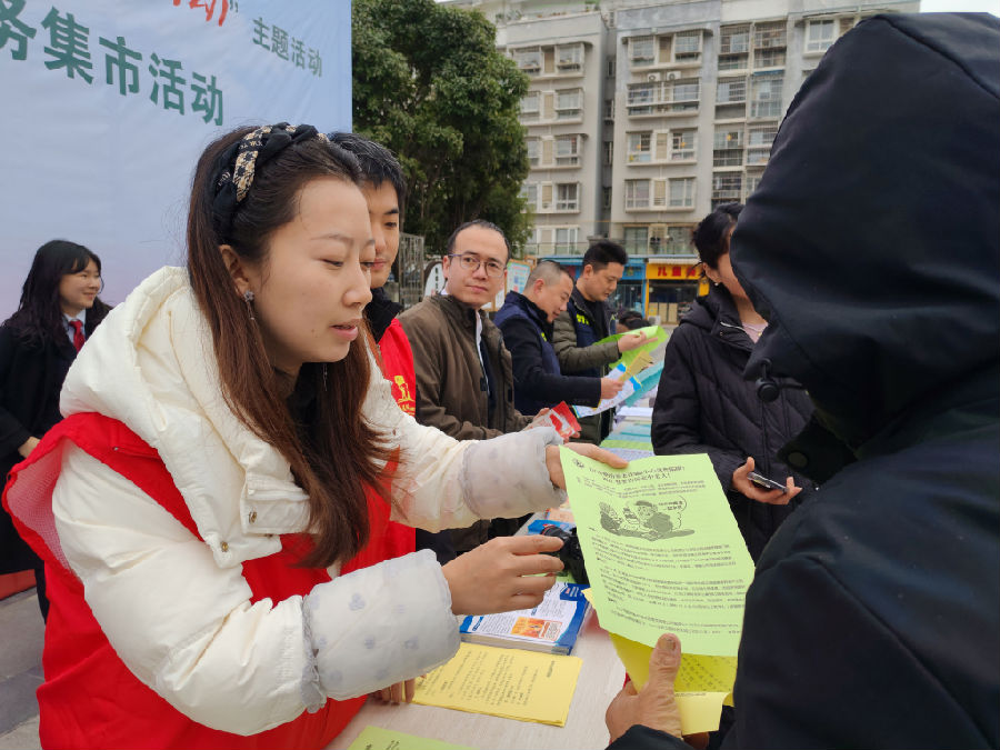 志愿者正在为群众进行惠民政策解答（张萍 摄）