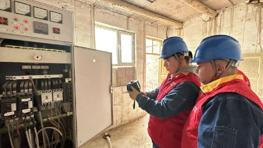 图为党员服务队为学校配电室进行用电检查、测温工作 （邸敏 摄）