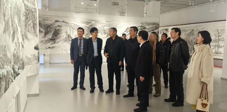著名画家赵明仁老师（左三）向参会领导和观众介绍创作思路和爱国主义教育初心（高山 摄）