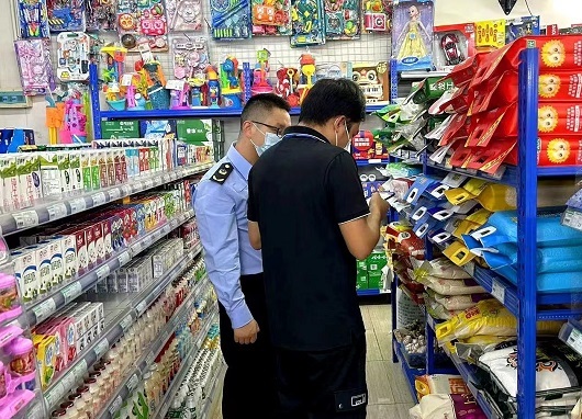 检查组对学校附近超市、便利店等进行抽检（黄春坚 摄）