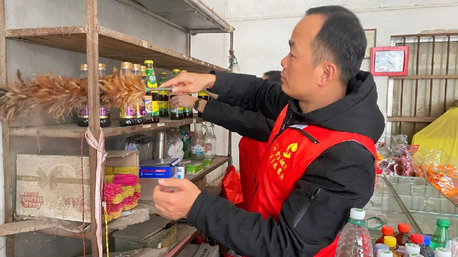 图为志愿者帮助零售户整理货架（黄杰生 摄）