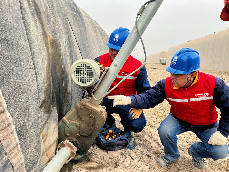 国网巴楚县供电公司员工为农户用电设备进行“义诊” （丁书远 摄）