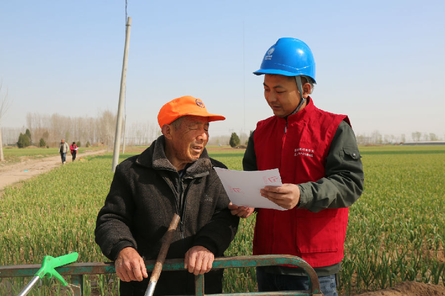 国网祥符供电公司焦裕禄共产党员服务队队员向农户宣传春灌用电安全知识（孟兰英 摄）