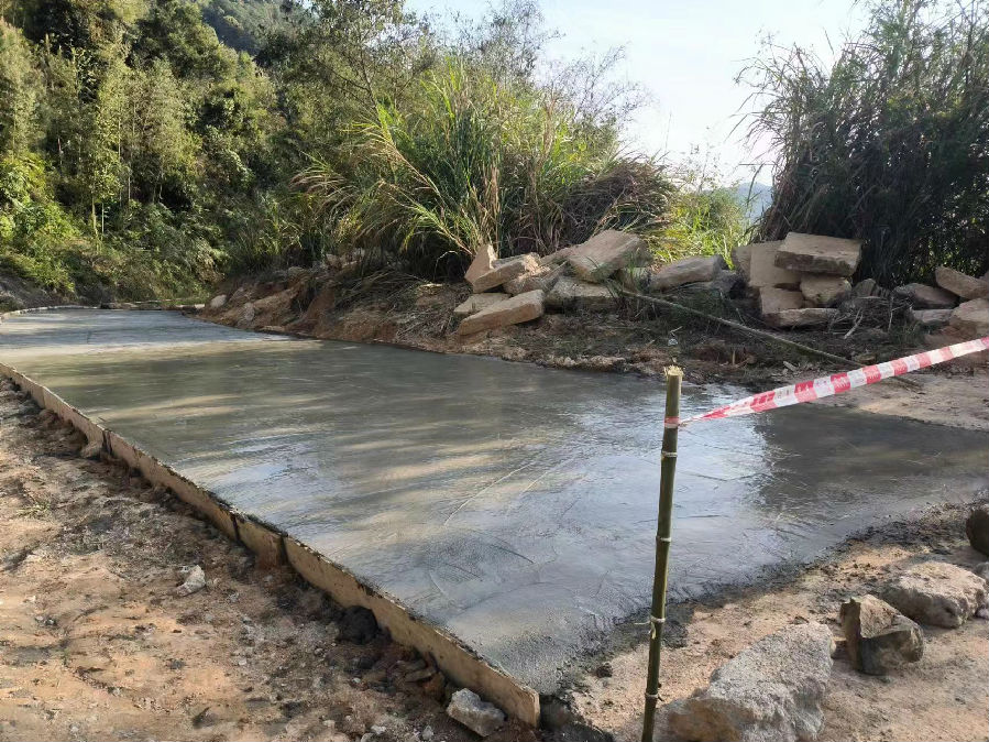 下田村的一段公路正在进行路面修复。（陈蕾 摄）