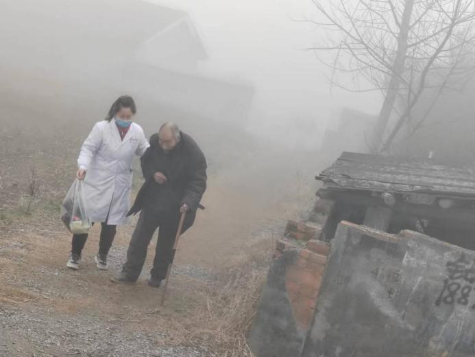 图为清晨陈琴正搀扶病人前往医院就诊 （张露月 摄）