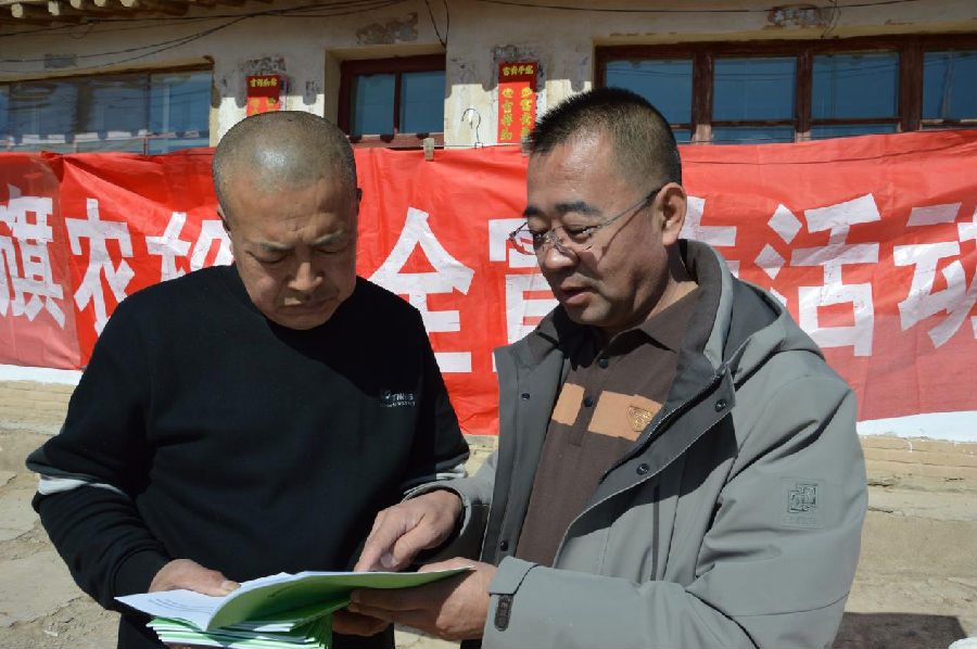 四子王旗农牧和科技局农牧业机械推广中心主任吴立华（右）向赵德龙详细讲解科学种植相关知识 （张蜀雁 摄）