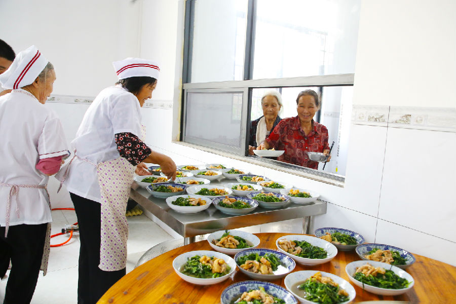 图为东津镇冲口屯老年人在爱心食堂领取饭菜（刘志宁 摄）