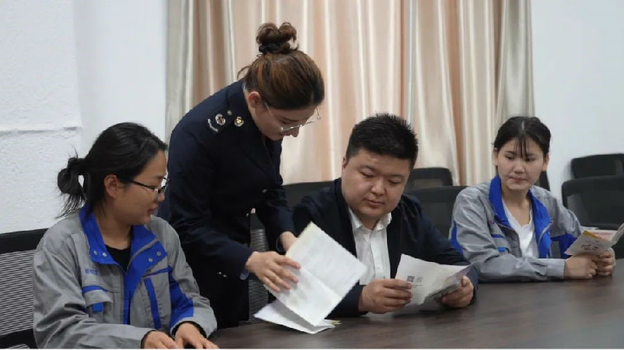 图为柯坪县税务局工作人员正在普及减税降费优惠政策（艾热提 摄）