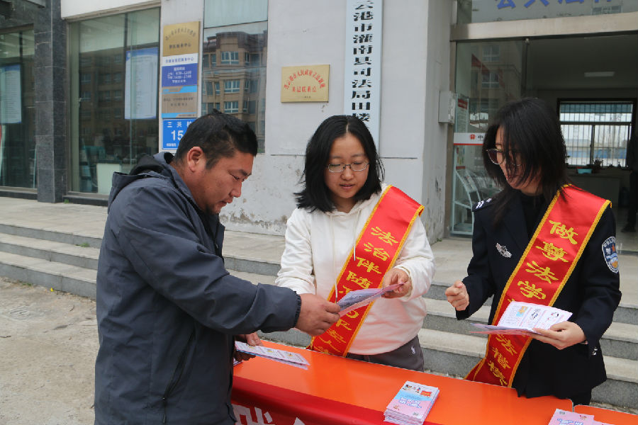 司法干警、普法志愿者、人大代表向群众宣传《民法典》（方明校 摄）