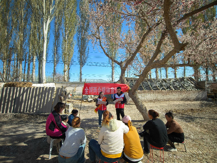 图为乌什县英阿瓦提乡青年宣讲员在农家院落宣讲全国两会精神（程斌 摄)