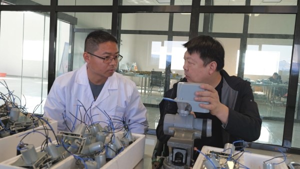 图为中国农业科学院棉花研究所的专家和公司的员工正在生产智能滴灌球阀（王旭 摄）