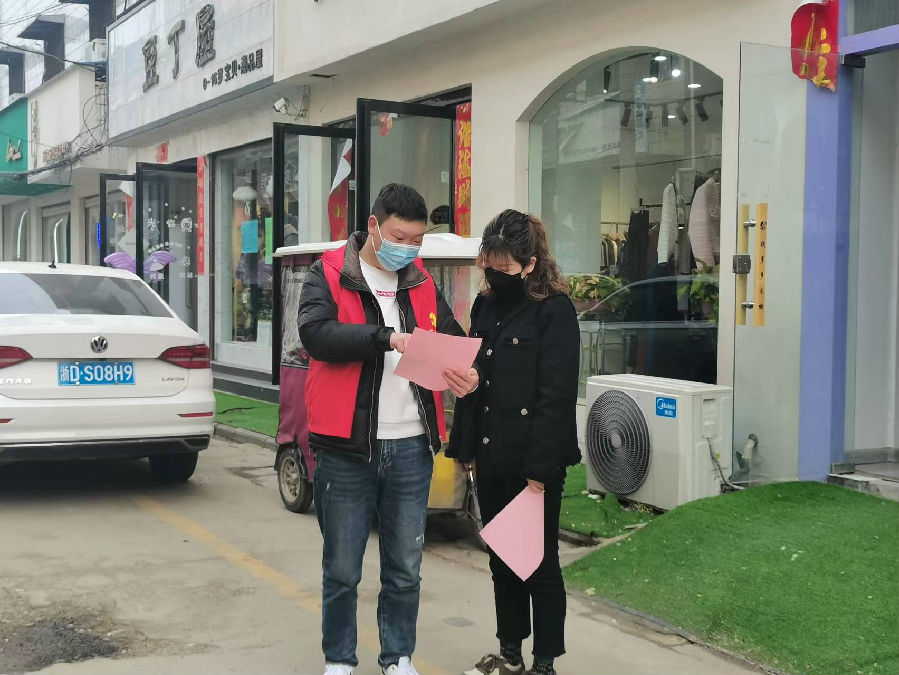 志愿者向居民讲解《创建国家级卫生县城须知》（赵兰奇摄）