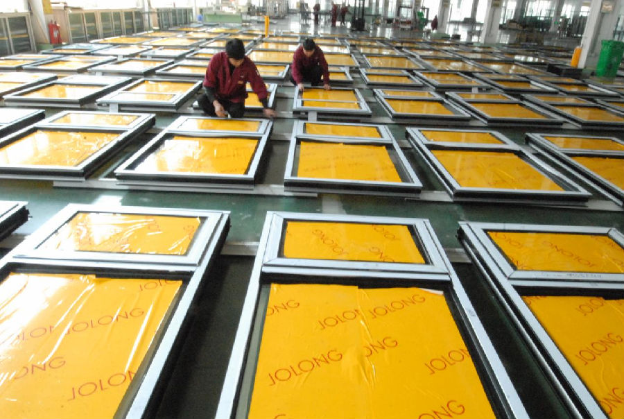 青岛兆龙门窗幕墙系统有限公司的工人正在忙着加工出口欧洲的门窗（张涛 摄）