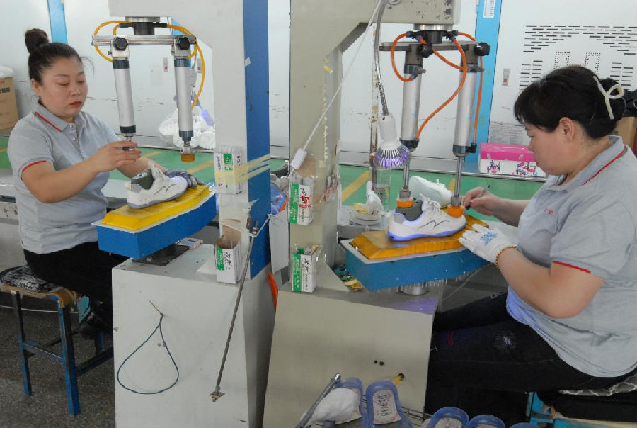 在青岛琴泽鞋业有限公司生产车间，制鞋工人正在忙着赶制订单（张涛 摄）