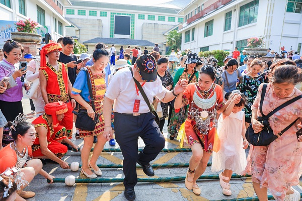 参加2024年海南黎族苗族传统“三月三”保亭主会场活动游客市民欢快地跳起竹竿舞。（文宏武 摄）