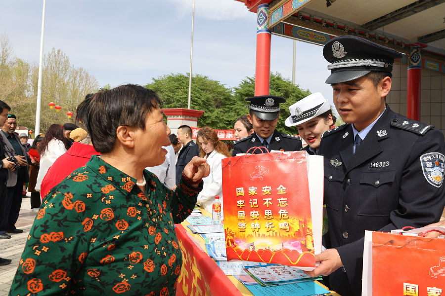 图为法制民警在广场向群众普及国家安全知识（胡国华 摄）