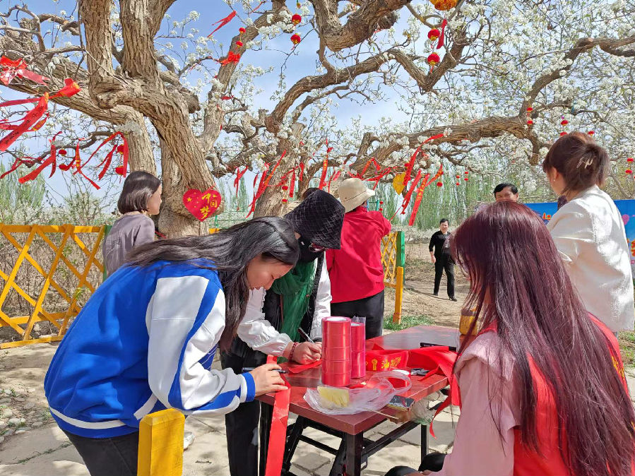 图为游客们用笔和红丝带写下对美好未来的期盼（李欣汶 摄）