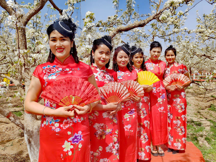 图为游人在温宿县克孜勒镇乌克铁热克村梨花园载歌载舞（玛依拉·阿不来提 摄）