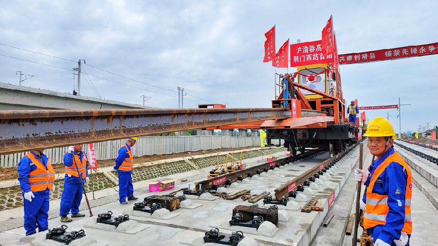 图为轨道铺设一体式铺轨机组在进行作业（郑晓东 摄）
