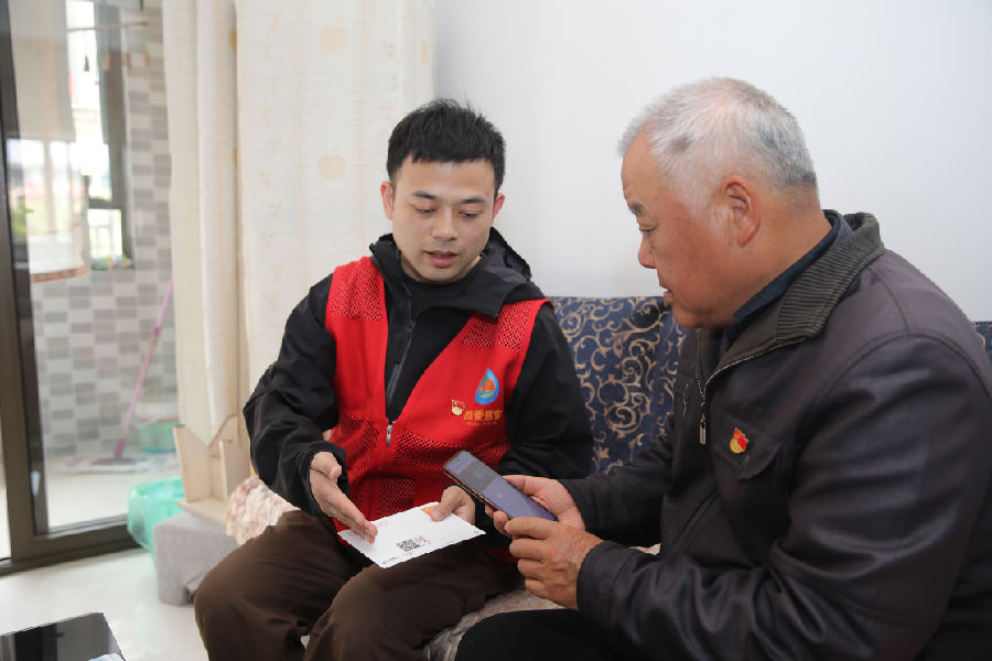 社区网格员、志愿者将“有声明信片”送到老党员家中（张伟伟 摄）