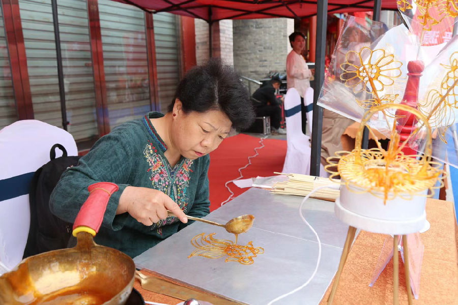非遗传承人正在精心制作糖画 （杨润德 摄）