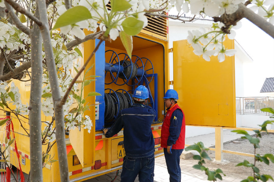 图为国网巴州供电公司阿瓦提乡供电所员工检查应急电源车运行情况（卢小银 摄）