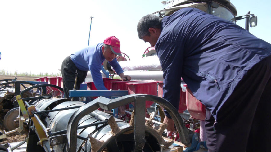 图为农机人员帮助农民检查农机(张勇 摄) 图为农机人员帮助农民检查农机(张勇 摄)