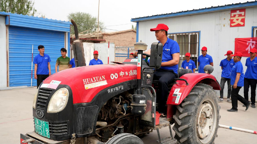 图为学员们在教练的指导下亲历拖拉机驾驶操控（李哲清 摄）