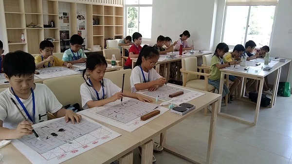 少儿们联系毛笔书法场景（陈晓婷 摄）