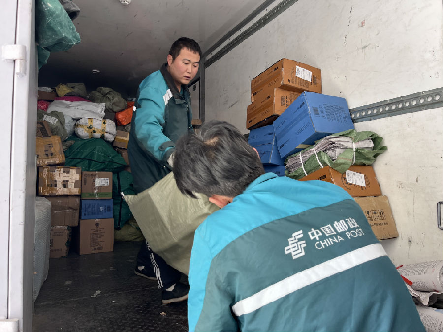 图为快递员在搬运包裹(杨家佳 摄)