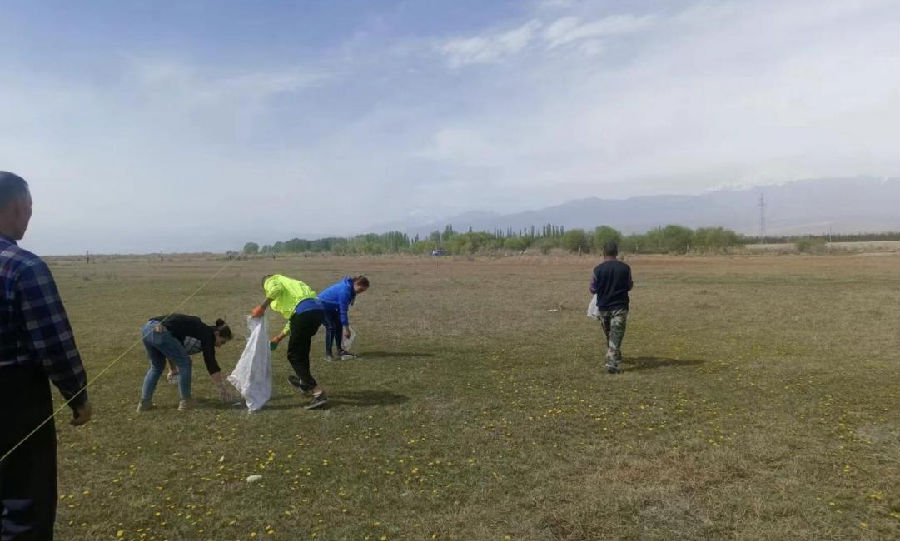图为村民和志愿者在湿地清理游客留下的垃圾（张巷归 摄）