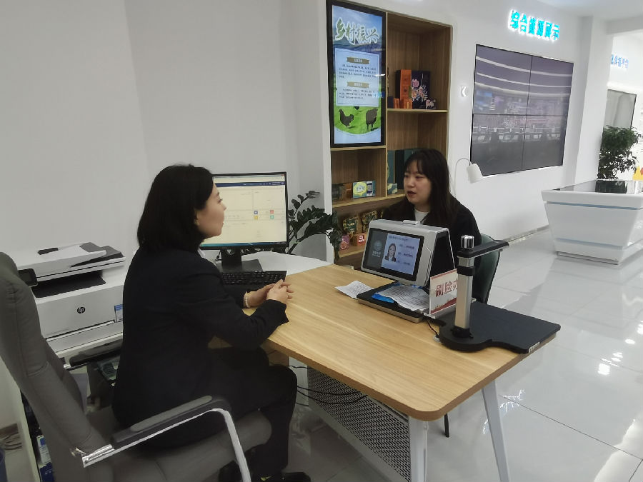 工作人员正在为居民刷脸办电（赵艳微 摄）