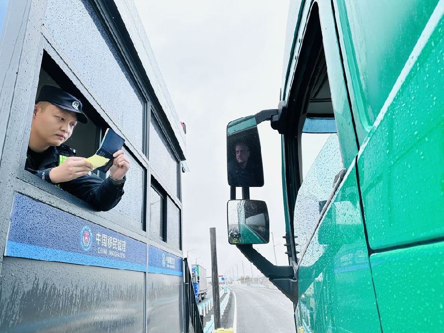 阿拉山口出入境边防检查站公路执勤现场民警对入境货车司机进行人证核对（赵越 摄）