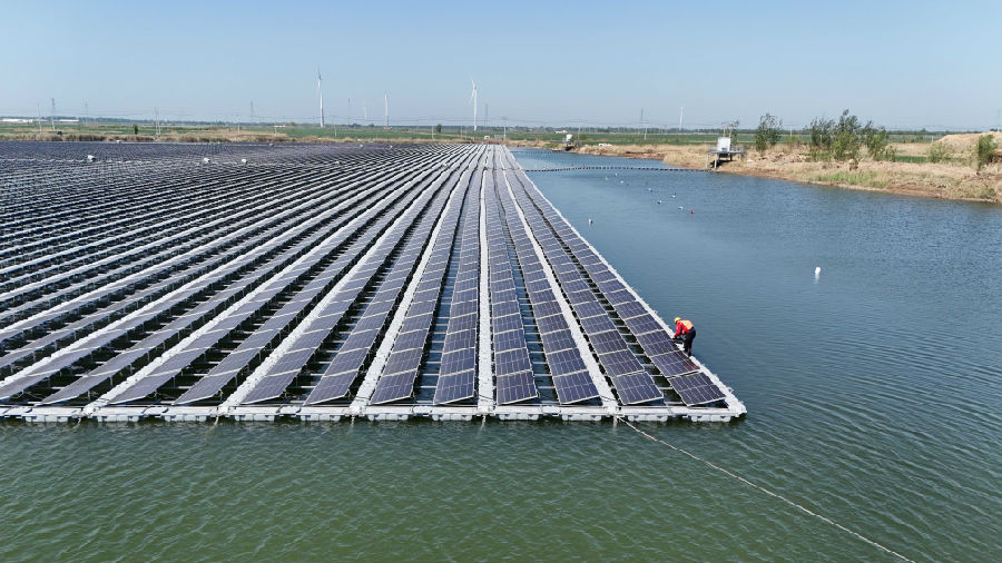 2024年4月24日，在山东省乐陵市铁营镇乡村振兴衔接工程“渔光互补”光伏发电站，国网乐陵供电公司工作人员正在巡查。（贾鹏 摄）