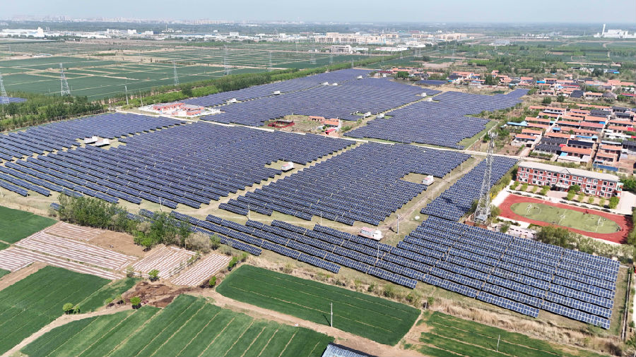 2024年4月24日，在山东省乐陵市铁营镇乡村振兴衔接工程“渔光互补”光伏发电站，一块块光伏发电板依次排布漂浮在水面，与房屋村舍相互映衬，构成一幅“光伏与渔业互补”的美丽生态画卷。（贾鹏 摄）