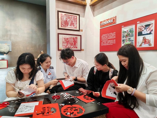 亲手实践黎族的剪纸技巧（唐芬 摄）