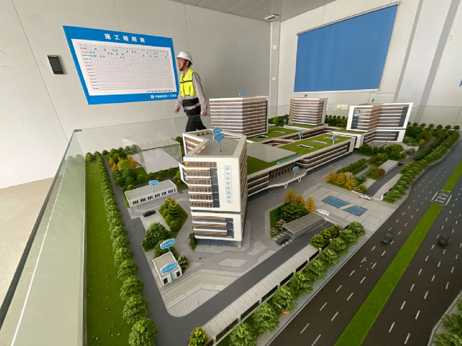 一名工作人员从劳动竞赛之一的重点工程项目模型前走过（申维祖 摄）